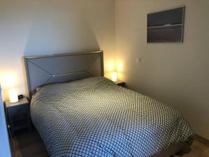 a bed in a bedroom with two lights on two tables at Appart cosy 3 pièces, ski-in/out, piscine & spa, 8-10 pers. - FR-1-461A-26 in Arc 1600 +24 photos