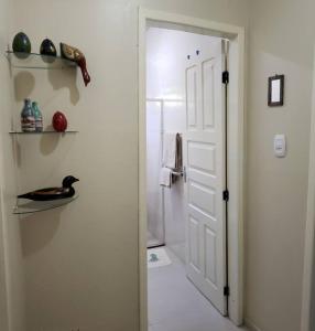 een witte deur die leidt naar een badkamer met een douche bij Casa atrás do Horto florestal in Santa Maria Madalena