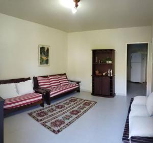 een woonkamer met 2 banken en een tapijt bij Casa atrás do Horto florestal in Santa Maria Madalena