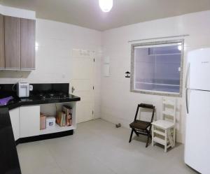 a kitchen with a chair and a window in it at Casa atrás do Horto florestal in Santa Maria Madalena