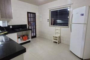 een keuken met een witte koelkast en een raam bij Casa atrás do Horto florestal in Santa Maria Madalena +11 foto's