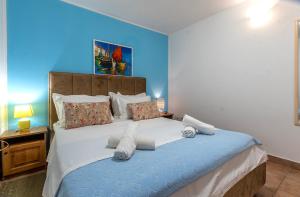a bedroom with a large bed with a blue wall at vila ivan i ian in Stanići +62 photos