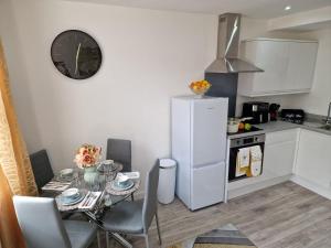 a kitchen with a table and a clock on the wall at 12 B Market Street in Watford