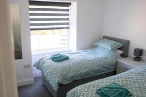 2 letti singoli in una camera da letto con finestra di No.9 Priory House, Bodmin a Bodmin