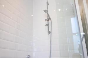 e bagno con doccia e piastrelle bianche. di No.9 Priory House, Bodmin a Bodmin