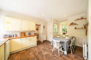 una cucina e una sala da pranzo con tavolo e sedie di Red Squirrel Cottage, Family & Pet Friendly Adventure Retreat, Strathdon, Aberdeenshire a Towie