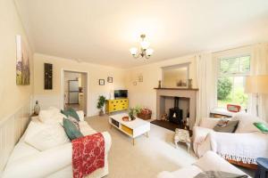 un soggiorno con un divano bianco e un camino di Red Squirrel Cottage, Family & Pet Friendly Adventure Retreat, Strathdon, Aberdeenshire a Towie