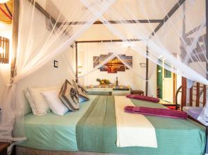 a bedroom with a large bed with pillows on it at Frangipani Beach Villa in Tangalle +187 photos