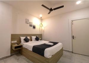 a bedroom with a bed with a ceiling fan at Frenotel in Hyderabad
