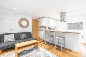 ブライトン＆ホーブにあるCharming & Chic, Cosy Beach Nest, Just 2-min walk!のソファとキッチンのあるリビングルーム