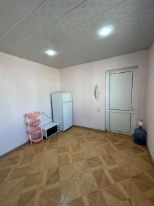 ein leerer Raum mit einem Kühlschrank und einem Holzboden in der Unterkunft Elegant Red House in Baku + 15 Fotos
