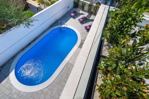 a blue swimming pool on a patio with plants at Villa Diana 2 Zaton in Zaton