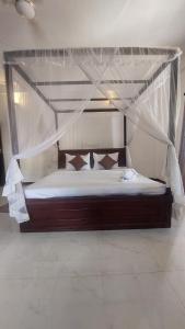 un lit à baldaquin dans une chambre dans l'établissement Solace Villa, à Dikwella