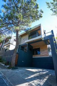 una casa con un albero davanti di R-Haus Baguio a Baguio