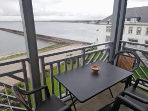 a table and chairs on a balcony with a view of the water at Résidence Saint Goustan in Le Croisic