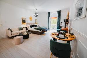 a living room with a couch and a table at RoomChic - Les Ambassadeurs in Vichy