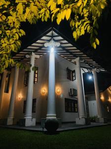 un bâtiment illuminé avec des colonnes et une lumière dessus dans l'établissement Solace Villa, à Dikwella