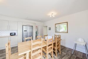 a kitchen and dining room with a wooden table and chairs at Auchenlarie Farmhouse in Gatehouse of Fleet