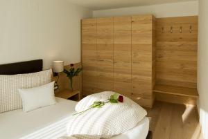 1 dormitorio con cama blanca y pared de madera en Villa Ried, en Perca