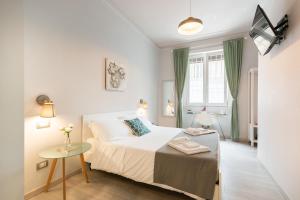 Un dormitorio blanco con una cama y una mesa. en Winkler Suites, en Roma