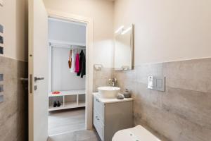 Un baño con lavabo, inodoro y espejo. en Winkler Suites, en Roma