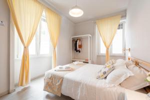 1 dormitorio con cama blanca y cortinas amarillas en Winkler Suites, en Roma