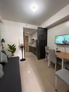 a living room with a dining table and a television at Studio Units at Shore Residences Condo MOA Complex near Airport in Manila