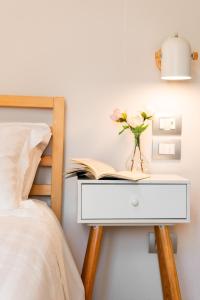 una mesa con un libro y un jarrón con una flor. en Winkler Suites, en Roma 37 fotos más