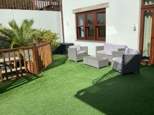 a patio with green grass and chairs on it at polgoon Vineyard annex Penzance in Penzance