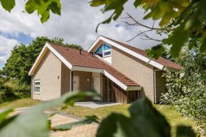een stenen huis met een bruin dak bij Vakantiepark Klein Vaarwater in Buren +41 foto's