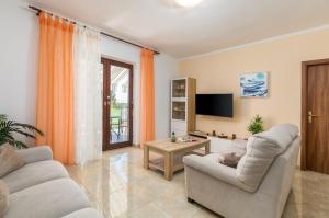 a living room with two couches and a tv at House Max in Mugeba