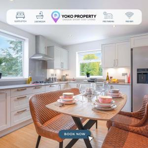 a kitchen with a table with plates and glasses on it at Stunning 2 Bedroom Apartment - Close to City Centre - Free Parking, Super-fast WIFI, SmartTV, Private Balcony and Communal Garden by Yoko Property in Coventry