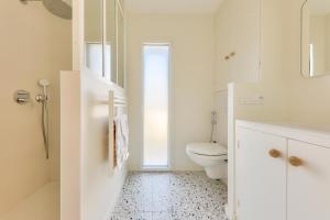 een witte badkamer met een toilet en een wastafel bij À 300m de la plage, belle maison neuve in Sarzeau +14 foto's