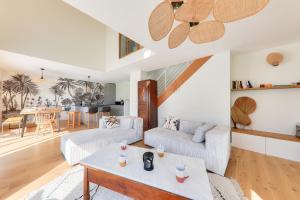 een woonkamer met twee banken en een tafel bij À 300m de la plage, belle maison neuve in Sarzeau