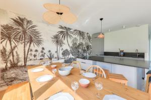 een eetkamer met een houten tafel met wijnglazen bij À 300m de la plage, belle maison neuve in Sarzeau