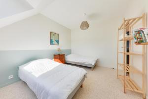 een slaapkamer met een bed en een boekenplank bij À 300m de la plage, belle maison neuve in Sarzeau