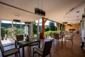 une salle à manger avec tables et chaises et de grandes fenêtres dans l'établissement W Krainie Alicji, à Nałęczów 10 autres photos