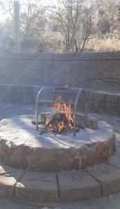 a fire in a stone oven in a yard at Assegai Lodge in Moheme