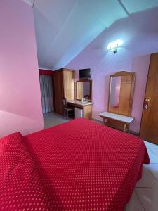 a bedroom with a red bed with a red comforter at Hotel Canada in Falerna Marina +24 photos