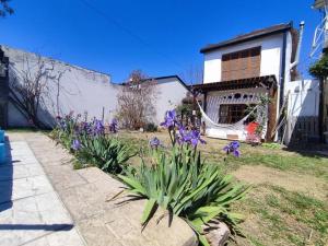 un jardín con flores púrpuras frente a una casa en Eco House, en María Juana
