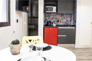 a kitchen with a white table and a red cabinet at Departamento 503 - Edificio VILAUT by INMOVE Temporarios in Córdoba