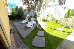 a garden with two lawn chairs and a tree at Casa di Davide in Sasso dʼOmbrone +3 photos