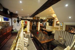 a pub with couches and a table and a fireplace at The Greyhound Coaching Inn in Lutterworth