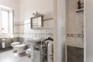 a white bathroom with a sink and a toilet at Casa Via Cesena in Rome +64 photos