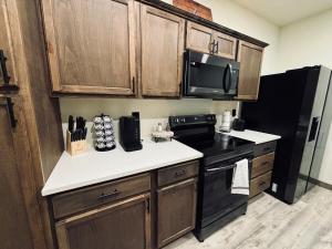 a kitchen with wooden cabinets and a black stove at Big Bear near Canyon Lakes in Kennewick
