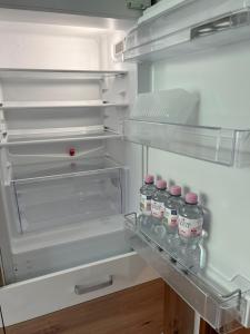 an open refrigerator with bottles of water on a shelf at Medina in Düsseldorf +5 photos