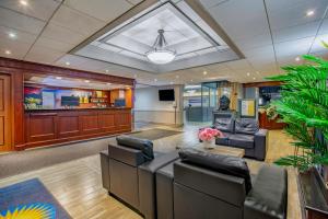 a living room with couches and a tv in it at Days Inn by Wyndham Sudbury & Conference Centre in Sudbury
