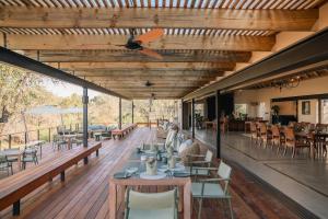 a restaurant with tables and chairs and a ceiling fan at Thornybush Simbambili Lodge in Sabi Sand Game Reserve