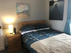 ein Schlafzimmer mit einem Bett und einer Kommode mit einem Nachttisch in der Unterkunft Victorian Flat in Bonhill