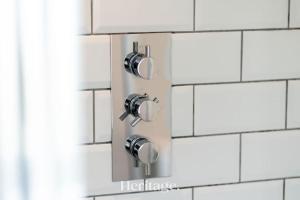 a bathroom with white tiled walls and chrome fixtures at Beach Cottage, Pet & Family Friendly Stay in Moray in Lossiemouth +39 photos